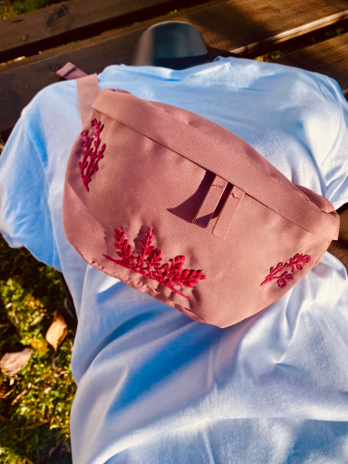 Sac banane rose brodé de motifs fleuris en fuchsia. Sac banane rose brodé de motifs fleuris en fuchsia.