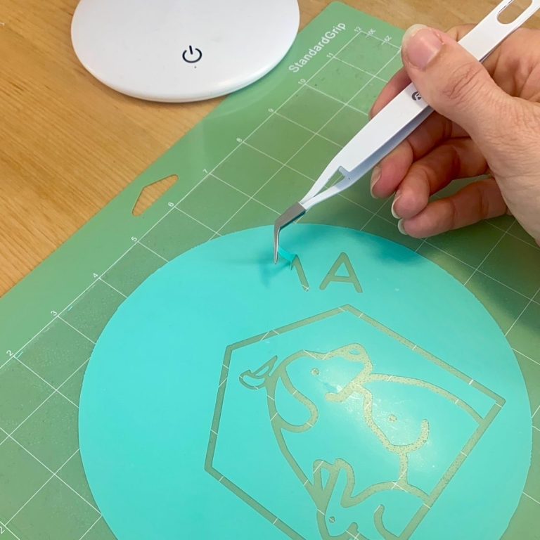 Jennifer est en train de détourer un logo avec une pince afin de le floquer ensuite. Photo de mon travail